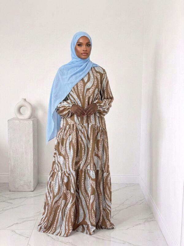 Robe Élégance ample Haute Silhouette avec attache à l'intérieur pour cintré – Spécial Grandes Tailles jusqu'à 1m85 Laisse-toi sublimer par cette robe longue à motifs, pensée pour les femmes grandes qui refusent de faire des compromis entre style, confort et élégance . Coupe longue et fluide, parfaitement adaptée aux silhouettes mesurant jusqu'à 1m85  sans retouches nécessaires. Manches bouffantes raffinées avec finitions soignées, pour une allure à la fois féminine et structurée. Fermeture boutonnée discrète au niveau du cou, pour une touche de pudeur chic et un port de tête sublimé. Lien d’attache intégré à l’intérieur, permettant de cintrer subtilement la taille sans altérer le tombé naturel du tissu. Motif signature : une harmonie parfaite entre modernité et élégance intemporelle. Conçue pour t’accompagner dans tous tes moments forts, cette robe incarne l’ADN Belinia Prestige : la mode qui t’élève, à ta hauteur. Va jusqu'à la taille 64 TAILLE UNIQUE de 1m85  ATTENTION : Robe très longue : Longueur de la robe 1m65 ATTENTION VRAI Grande Taille : Taille unique, penser à bien vérifier la LONGUEUR avant toutes commandes.